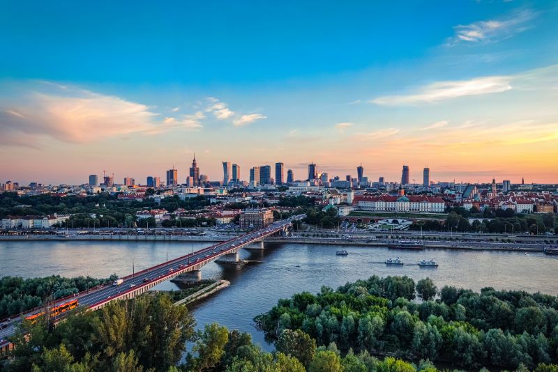 Panorama of Warsaw with the Świętokrzyski Bridge in the foreground and skyscrapers in the background, during sunset.