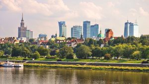 Panorama Warszawy z Wisłą, w tle nowoczesne drapacze chmur i historyczne budynki.