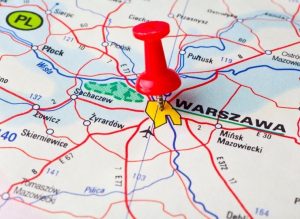 A map with a red pin placed on Warsaw, also showing nearby cities and roads in Poland.